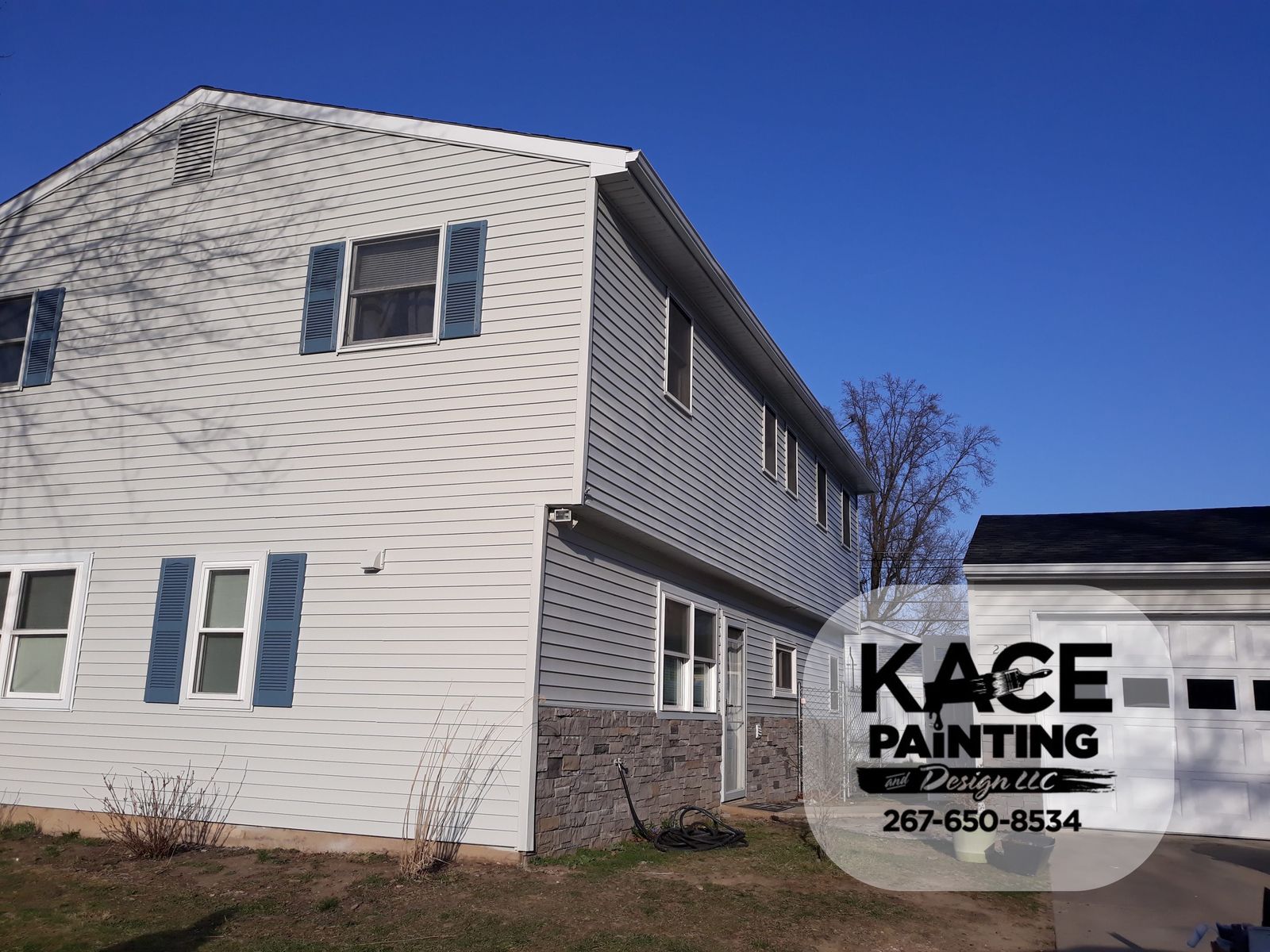 Two story home with light gray siding and blue shutters
