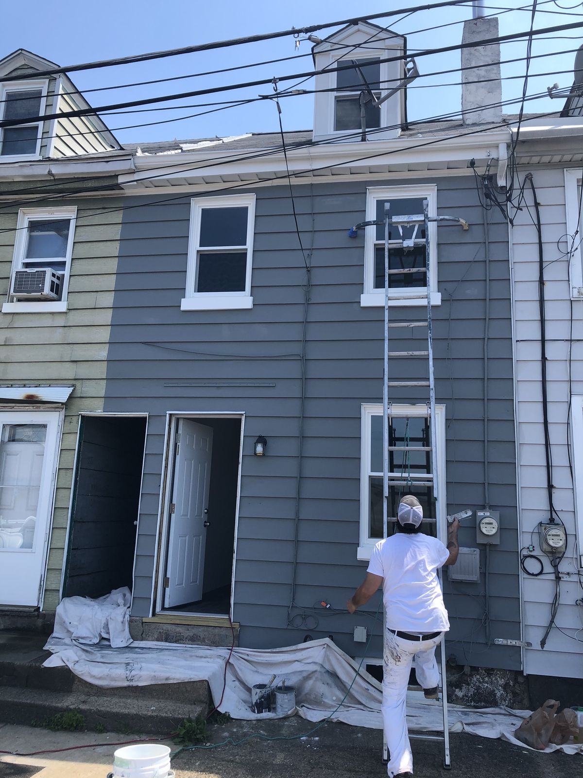 Painter working on the exterior of a row of twin homes