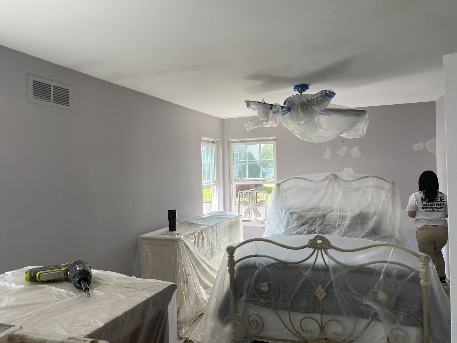 Bedroom with furniture wrapped and protected before painting begins