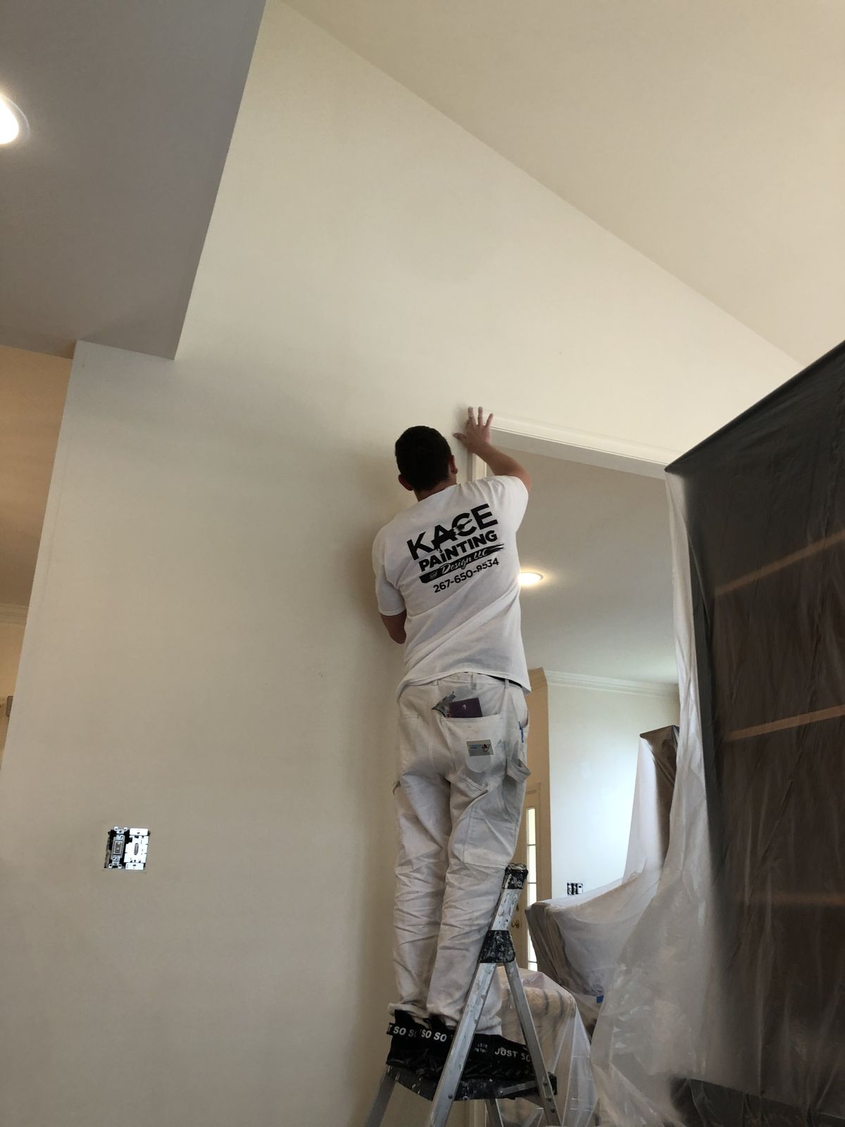 Painter cutting in a wall edge in a prepared room