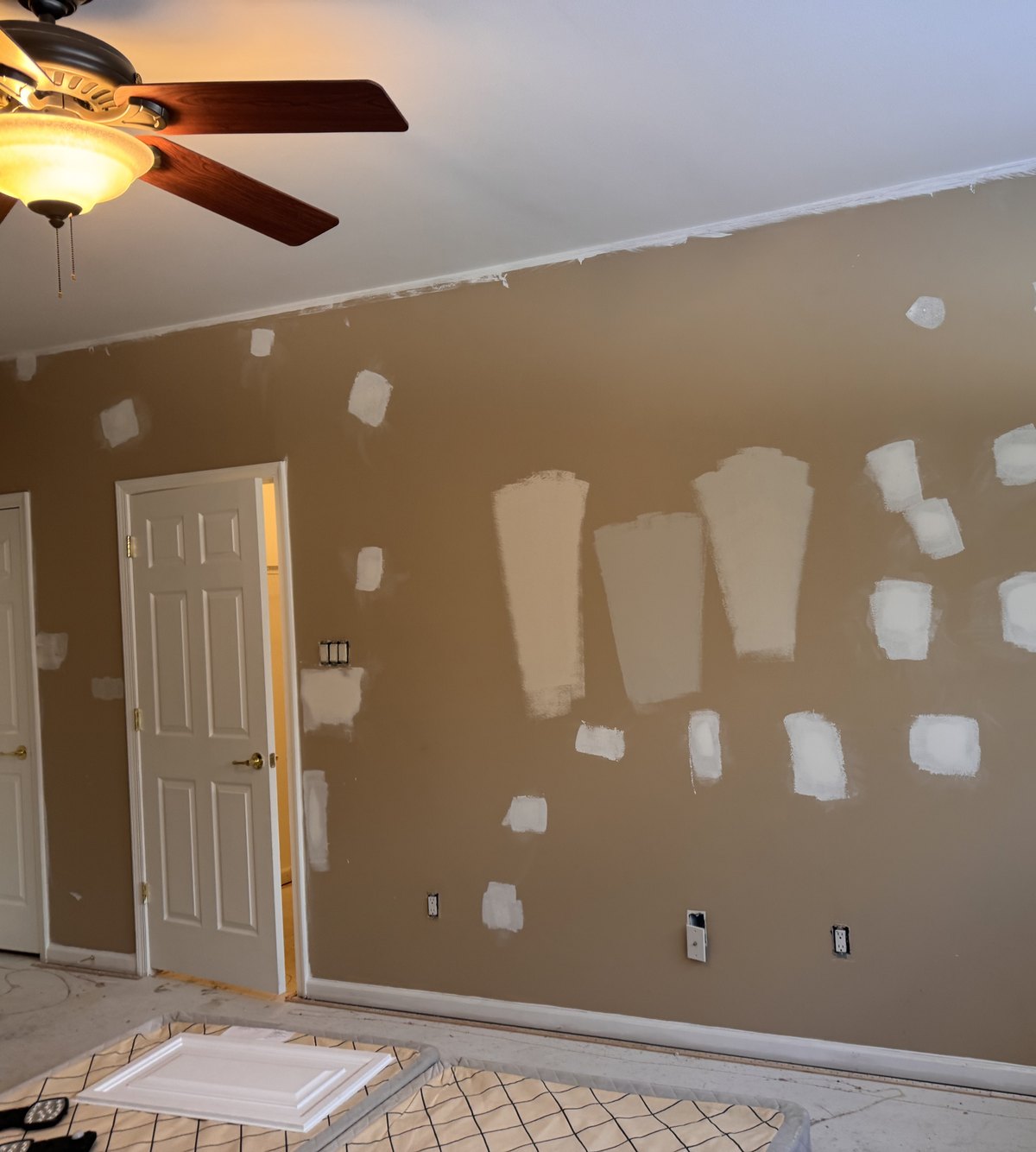 Paint color samples brushed onto a bedroom wall in a Newtown, PA home
