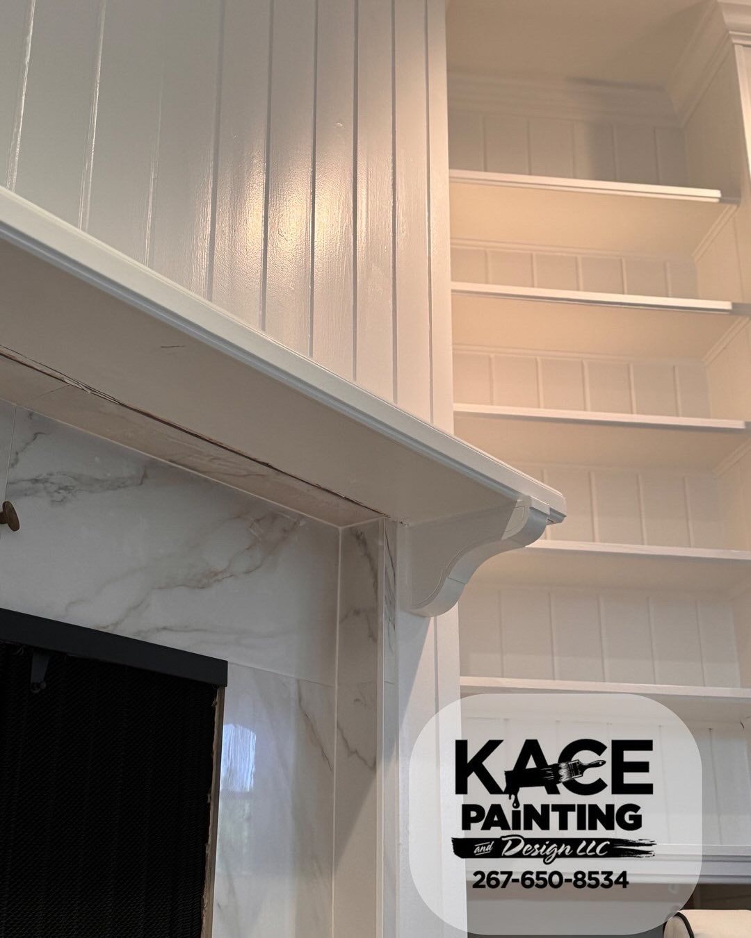 White painted built in shelving beside a marble fireplace