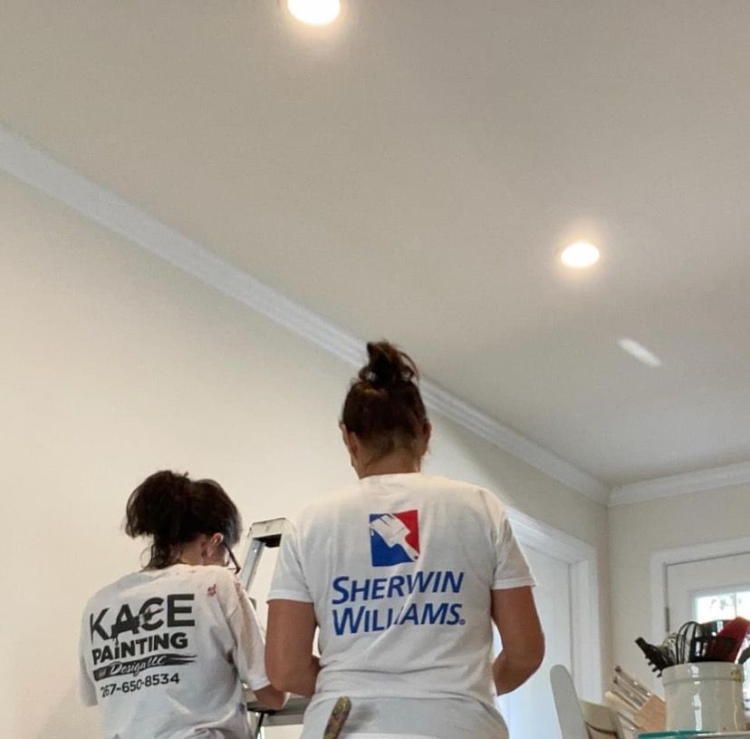 KACE painters working on a ceiling in a bright room