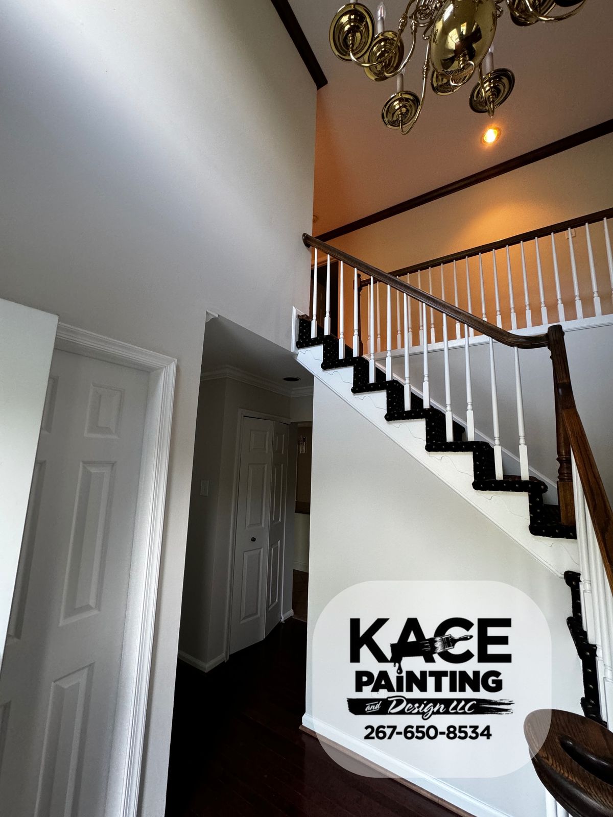 Staircase and entry hall with white trim and a chandelier