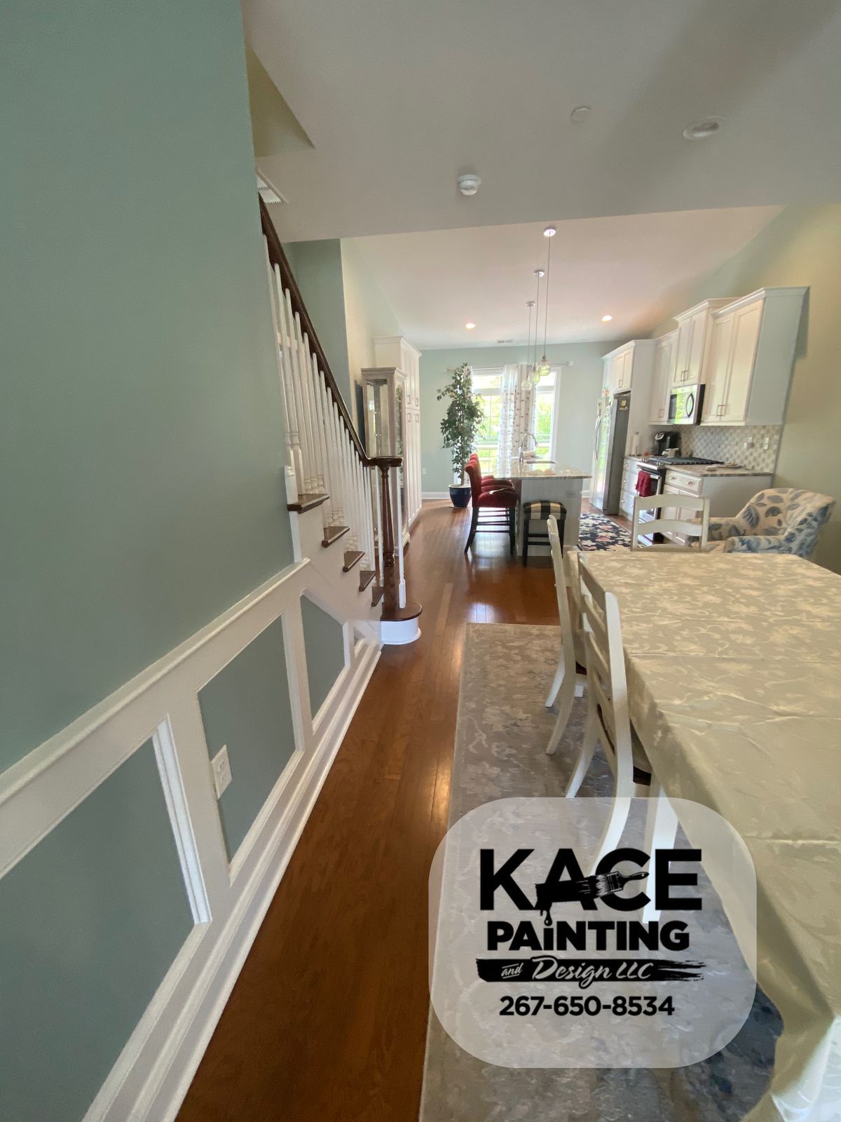 Hallway with white wainscoting leading through to a kitchen