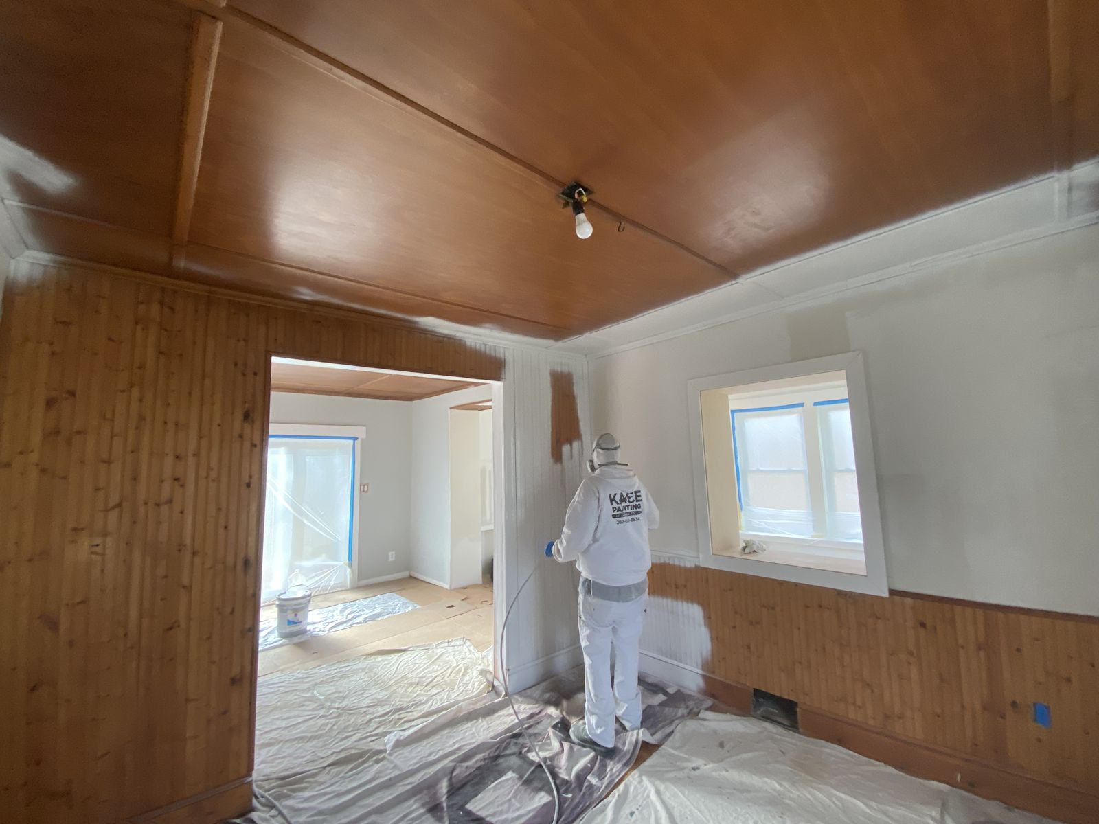 Wood paneled room primed and painted over