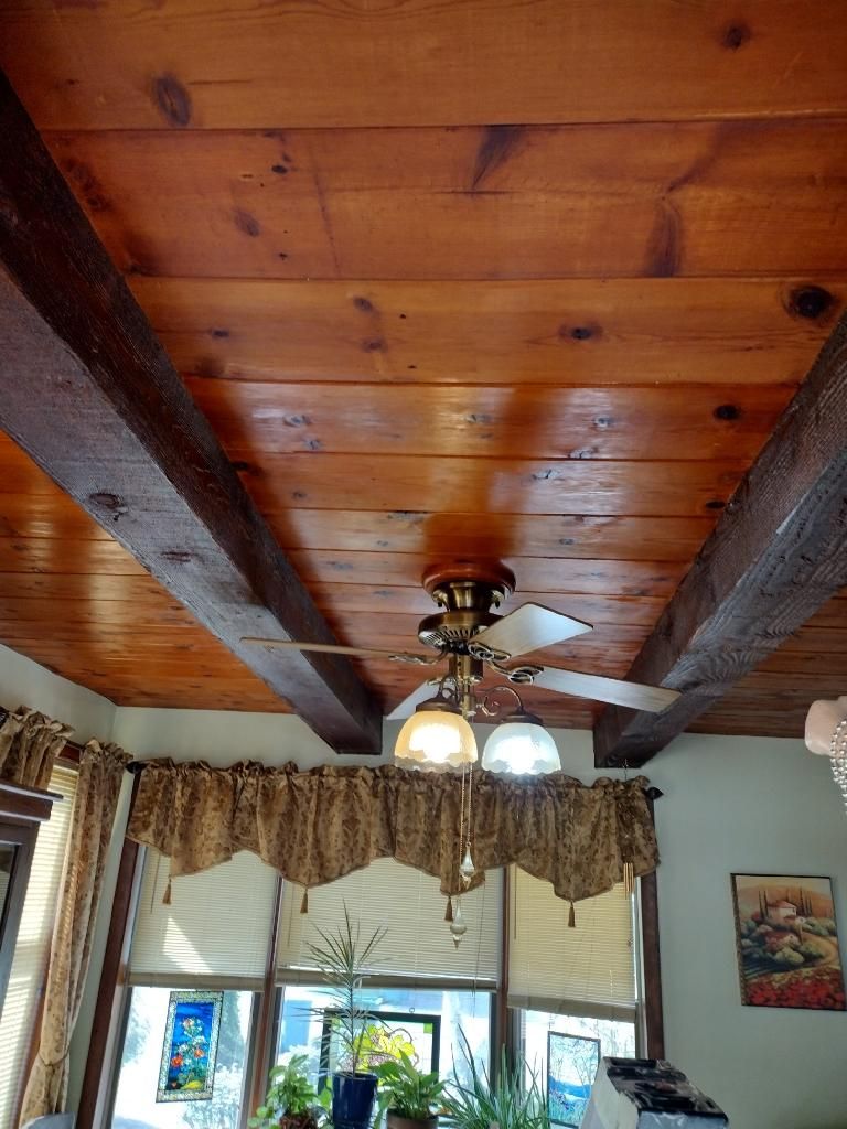 Room with a wood plank ceiling and ceiling fan