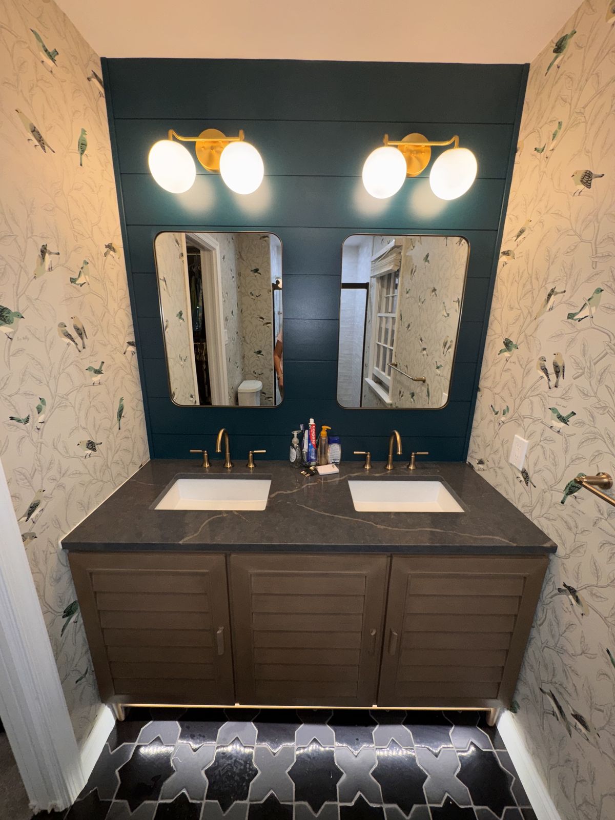 Powder room with dark teal wallpaper and a double vanity