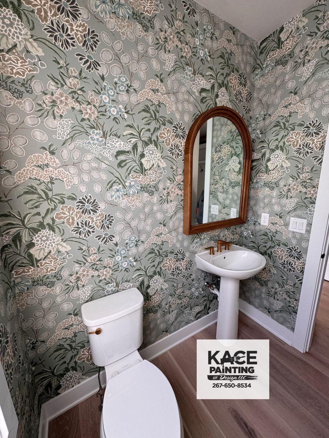 Powder room with botanical wallpaper and an arched mirror